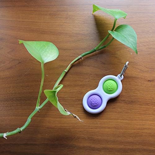 Fat Brain Toys sensory popping keychain attached to a school backpack for on the go use.