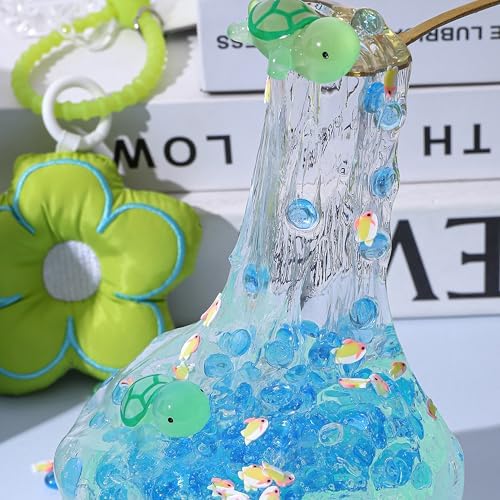 Close up view of the collectible miniature turtle toy charm inside the transparent blue beaded slime.