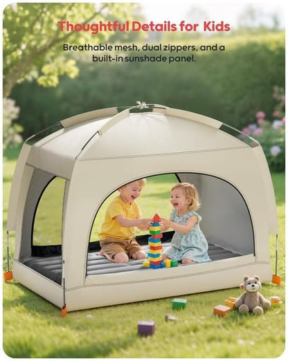 The QPAU toddler travel cot fully assembled outdoors in a garden setting highlighting its insect resistant mesh panels.