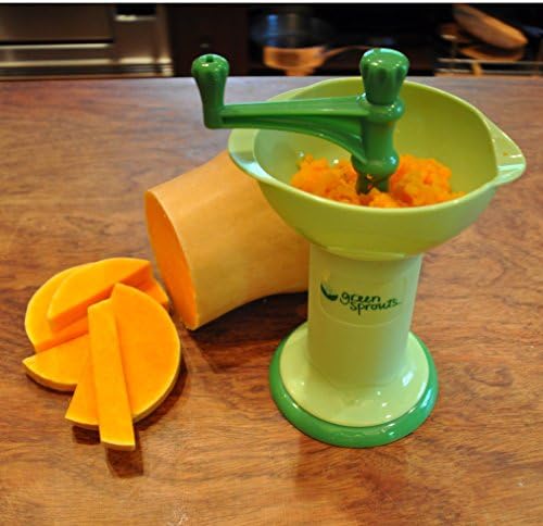 Compact Green Sprouts manual mill being operated by hand to create smooth fruit puree.