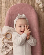 Dusty pink and avocado print baby changing pad on dresser