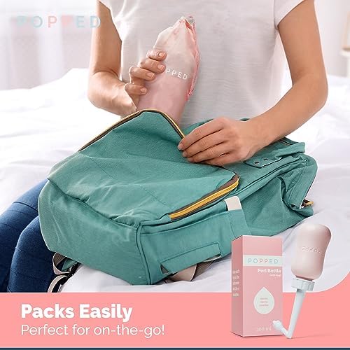 Pink Popped Peri Bottle being held to demonstrate soft squeeze material
