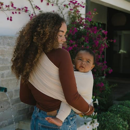 Side profile showing the ergonomic M-shape leg positioning of an infant in the WildBird carrier