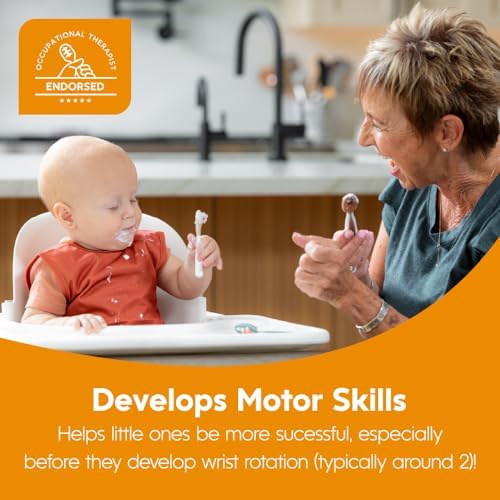 An infant safely holding the thick contoured handle of the gray toddler self feeding utensil.