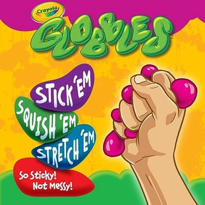 Adult hand squeezing a green Crayola Globble ball for office stress relief.