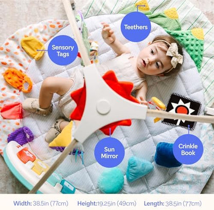 Infant playing with musical piano and sensory toys on gym mat
