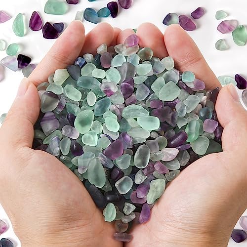 Close up of natural tumbled fluorite crystal chips showing green and purple hues