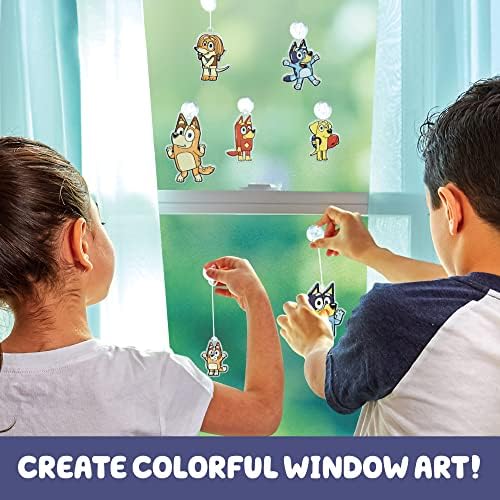 Completed Bluey character window art suncatchers hanging on a window glass reflecting natural sunlight.