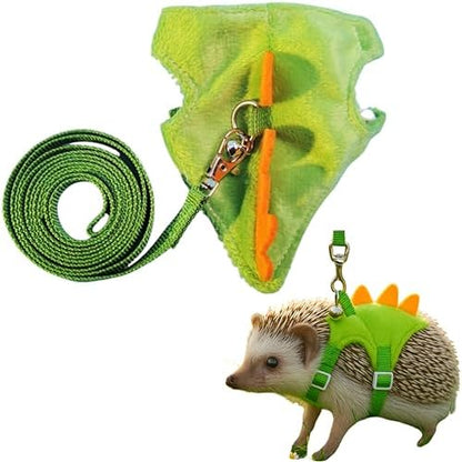Dinosaur shaped small pet harness with orange spikes and attached safety bell on a white background