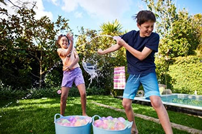 Bright tropical colored water balloons prepared and ready for a backyard summer party.