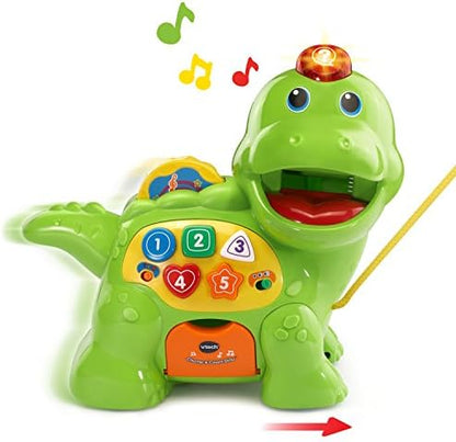 Toddler placing a colorful food disc into the VTech dinosaur mouth