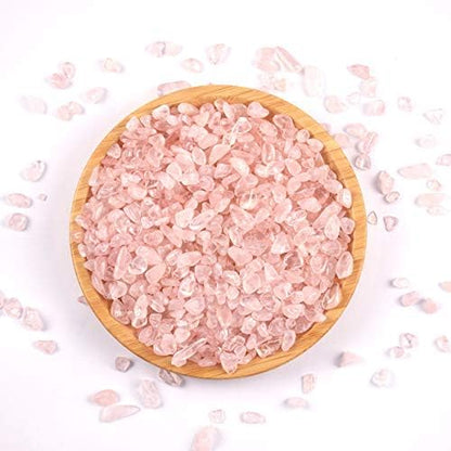 Hand holding a handful of natural irregular pink quartz stones