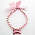 PetFavorites fancy pearls crystal dog necklace front view featuring pink ribbon bow and rhinestone bone charm.