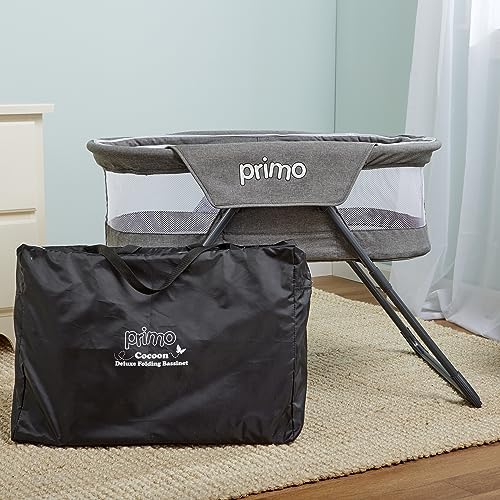 PRIMO portable baby bed collapsed flat next to its matching gray carrying tote bag.
