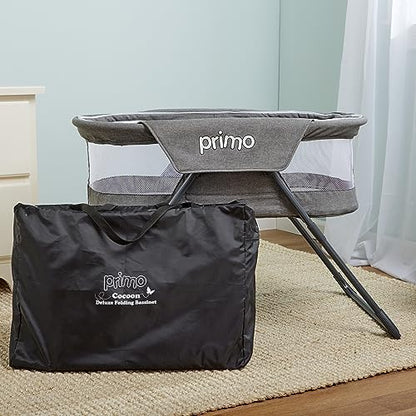 PRIMO portable baby bed collapsed flat next to its matching gray carrying tote bag.