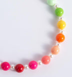Close up view of the heart shaped rhinestone charm on the handmade faux pearl pet jewelry.