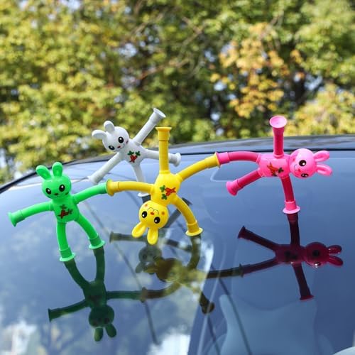 Miniature colorful telescopic bunny toys suctioned securely to a clear glass window pane.