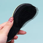 Ergonomic handle detail of the premium pet detangling brush showing flexible bristles.