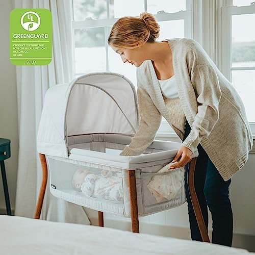 Chicco travel bassinet with removable canopy attached on wood grain legs