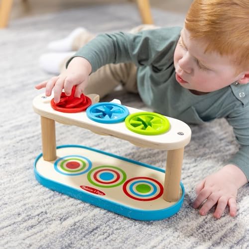 Toddler playing with Melissa and Doug Match and Push Spinning Tops toy
