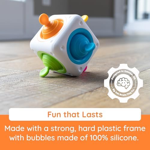Fat Brain Toys Tugl Cube being held by a user demonstrating the tactile push and pull mechanism