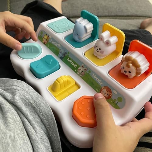 Toddler hands pressing the blue switch on the developmental sensory toy box.