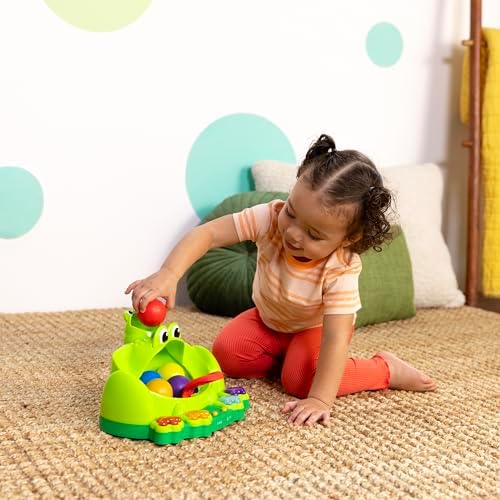 Bright Starts musical frog toy showcasing the battery compartment and durable design safe for babies six months and older.