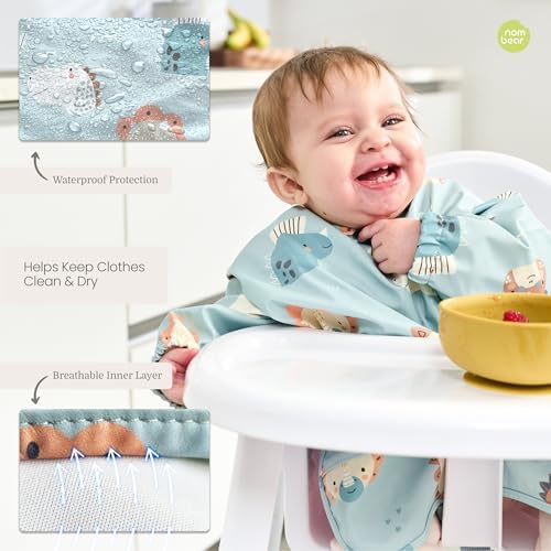 Waterproof baby bib being wiped clean of fruit stains under tap water