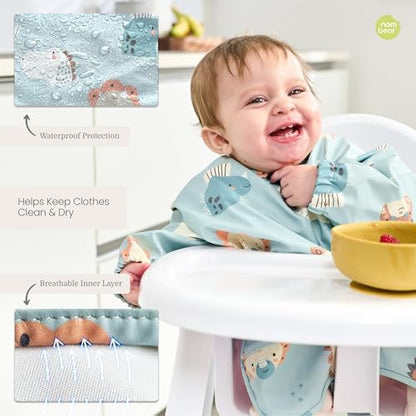 Waterproof baby bib being wiped clean of fruit stains under tap water