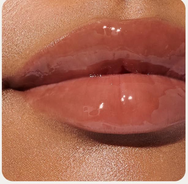 Glossy finish lip tint by Rhode applied sheerly on lips.