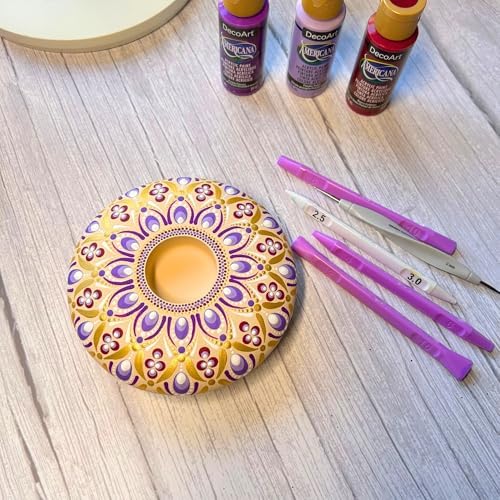 Artist using teardrop dotting tool for rock painting