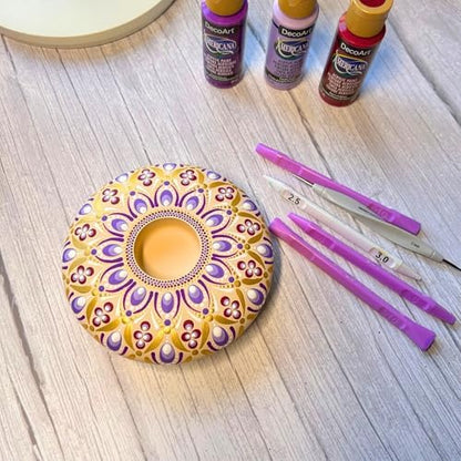 Artist using teardrop dotting tool for rock painting