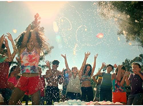 Durable natural rubber water balloons filling up over a water container for backyard summer play