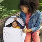 Mother using Munchkin breastfeeding cover in public