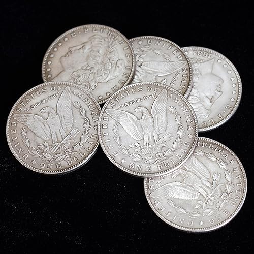 Magician holding replica Morgan Dollar coins for sleight of hand performance