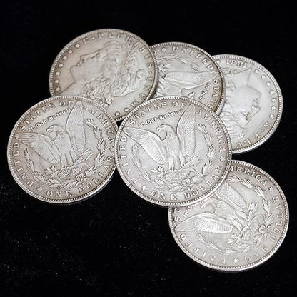 Magician holding replica Morgan Dollar coins for sleight of hand performance