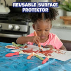 READY 2 LEARN kids splat mat blue color with art supply outlines placed under a toddler high chair