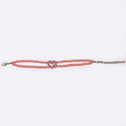 Small dog wearing pearl necklace with rhinestone heart charm