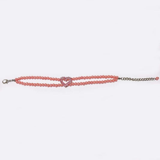 Small dog wearing pearl necklace with rhinestone heart charm