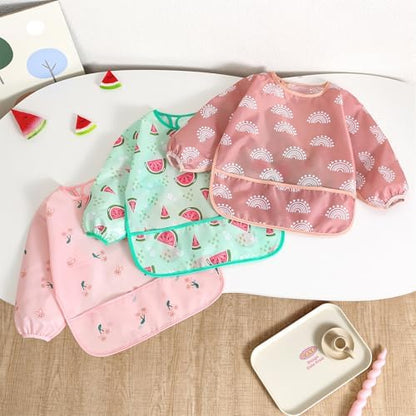 Toddler wearing a wearable waterproof sleeved smock apron with food catcher pocket