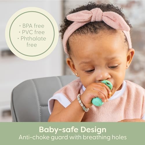 An infant safely holding the ergonomic chunky handle of the UpwardBaby self feeding silicone utensil.