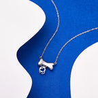 Wexibauyl silver tone pet memorial necklace on a presentation cushion.