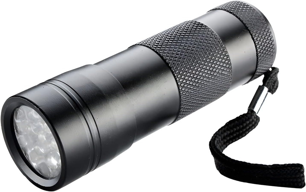 Handheld inspection blacklight torch revealing hidden pet urine stains on a domestic carpet.