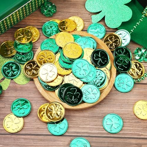 Green and gold metallic plastic lucky coins scattered on a white table display.
