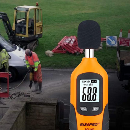RISEPRO acoustic testing meter being held in hand to demonstrate its compact and portable design.