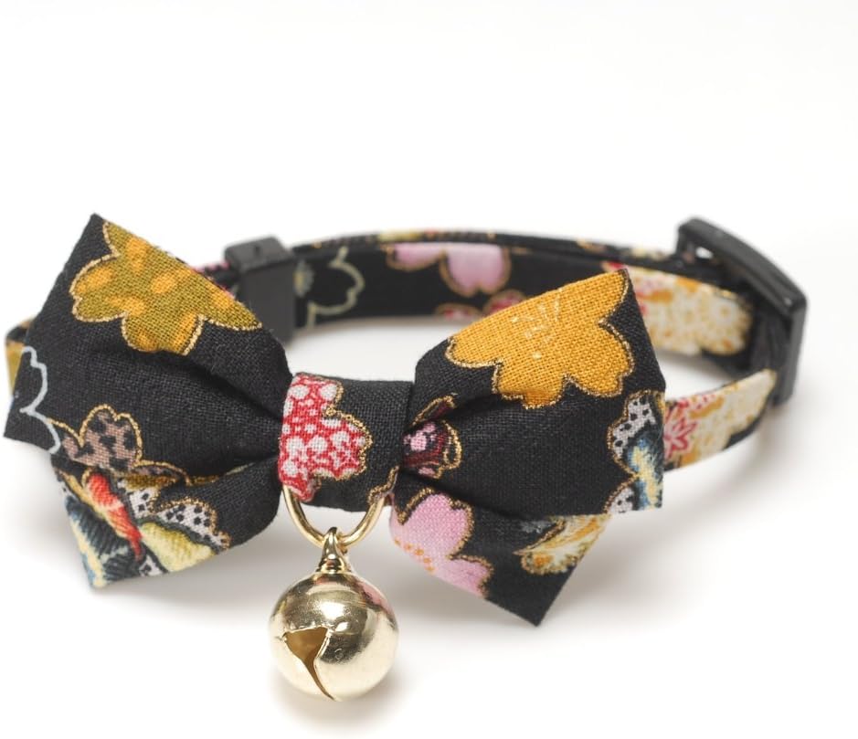 Necoichi black cat collar displaying the attached fabric bow tie and gold bell.