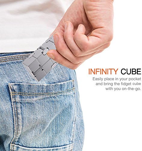 Adult holding the TAGUDA sensory metal cube in one hand demonstrating compact pocket size