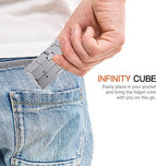 Adult holding the TAGUDA sensory metal cube in one hand demonstrating compact pocket size