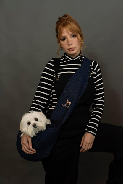 Small dog being carried in Noah and Paw denim sling