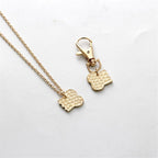 Detailed view of engraved letters on gold toned best friends charm jewelry